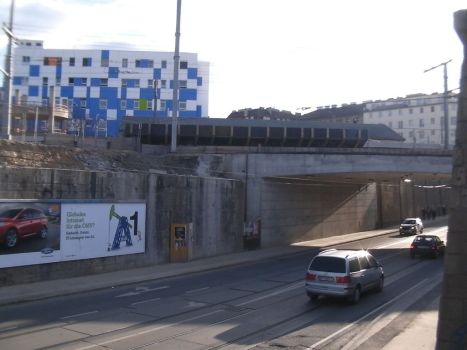 Rechts in Bildmitte ist das eine Feld der neuen Brücke zu sehen, das die Straße und die Straßenbahntrasse überspannt.  