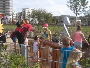 Kinder im Kleinkinderspielplatz bei der Wasserpumpe.
